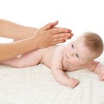 The feminine hands massage the cute baby boy