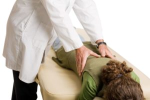 chiropractor doing adjustment on female patient.