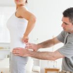 Chiropractor examining a woman's back