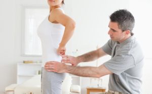 Chiropractor examining a woman's back