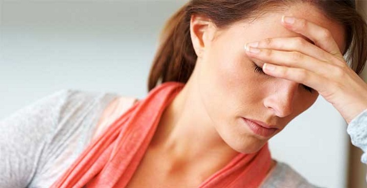 woman with depressed face holding her head