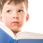 a boy with a book looking puzzled