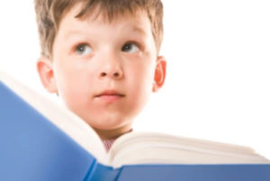 a boy with a book looking puzzled