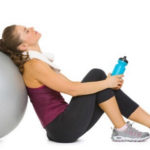 tired woman leaned on her pilates ball