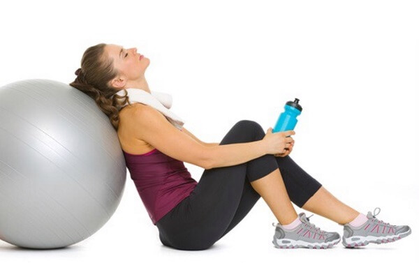 tired woman leaned on her pilates ball