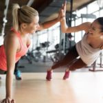 two young woman doing push ups and giving high five