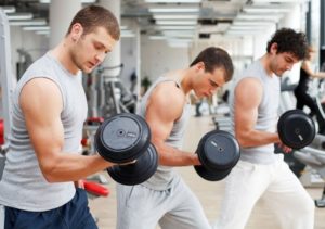 three men lifting weights in the gym