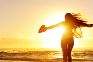 woman at the summer beach spreads her hands wide