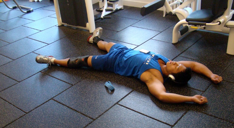 a guy resting on the floor in the gym