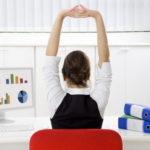 woman stretching at the office desk