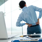 man with back pain at workplace