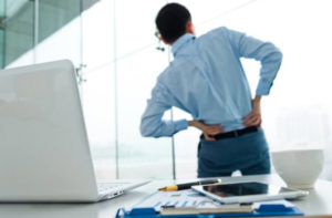 man with back pain at workplace