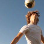 young athlete punching a ball with his head