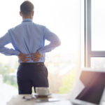 man with lower back pain in his office