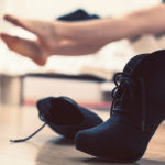 woman lying on the bed and her high heels next to it