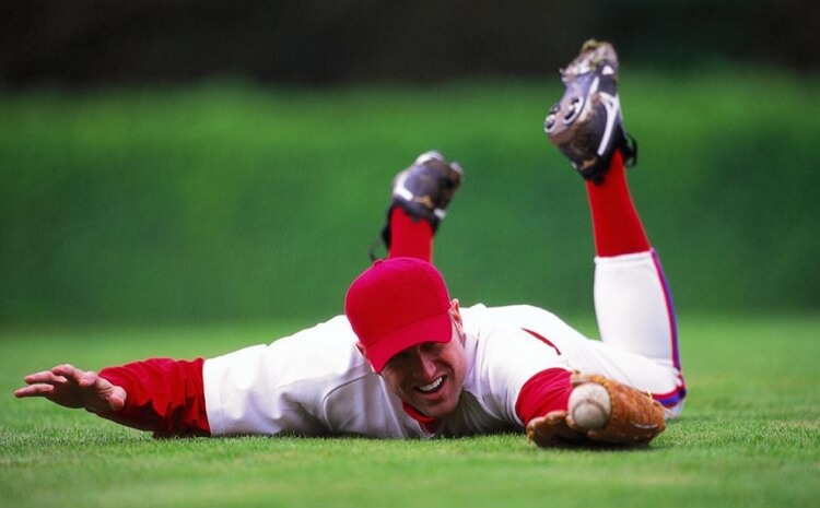 baseball player on the ground catching ball
