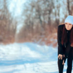 young woman with joint pain on winter background